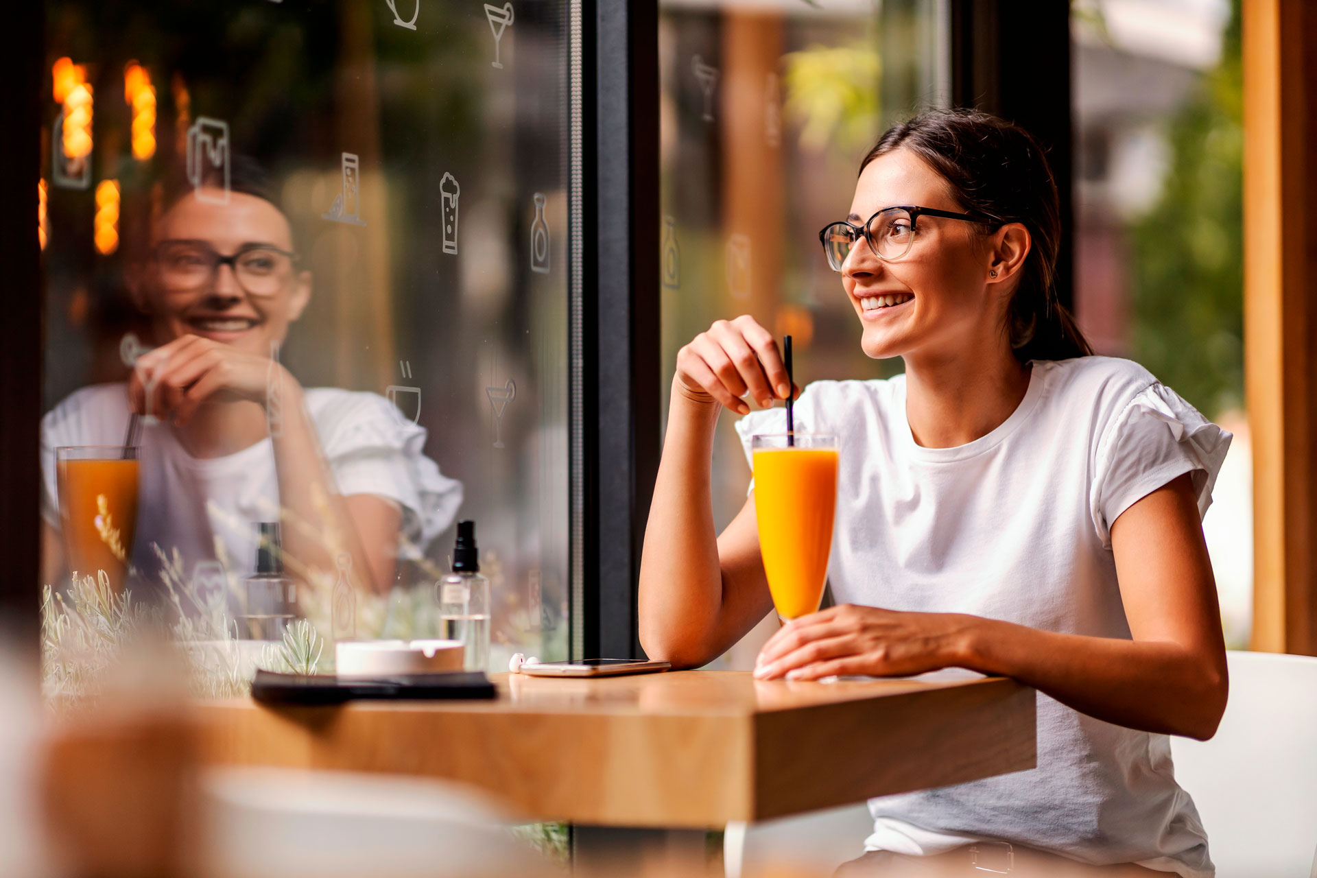 A woman smiling drinking a Rejooced juice drink by Beverage Genius